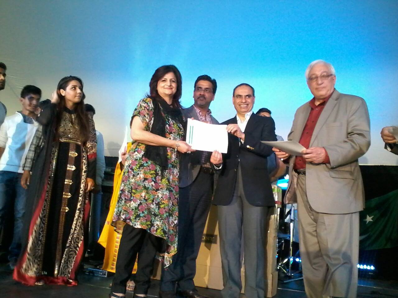 Gul receiving a recognition certificate at a community awards ceremony